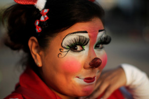 A clown poses for a picture in a parade during Salvadoran Clown Day celebrations in San Salvador, El Salvador