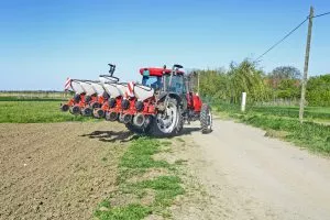 Farmer with a tractor sows corn